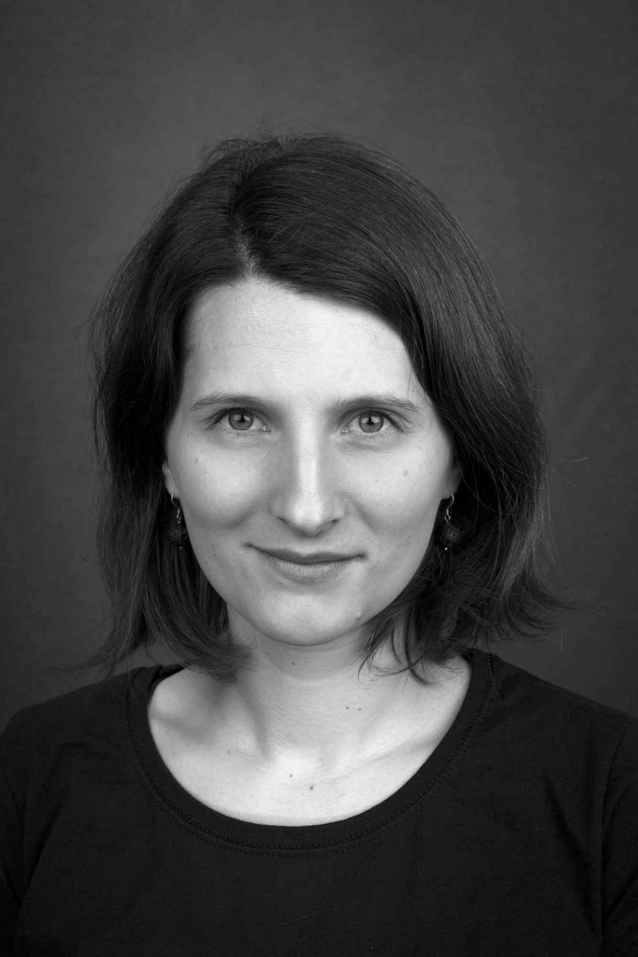 Svartvit porträttbild av Sara Sandén. Kort mörkt hör till hakan och svart T-skjorta.